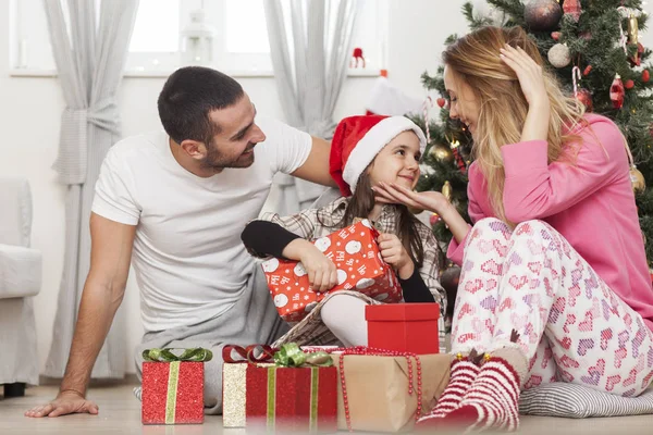 Familia frente a los regalos de apertura del árbol de Navidad —  Fotos de Stock