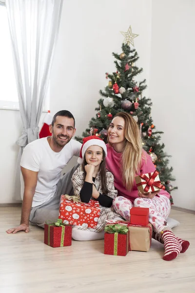 Família na frente de presentes de abertura de árvore de Natal — Fotografia de Stock