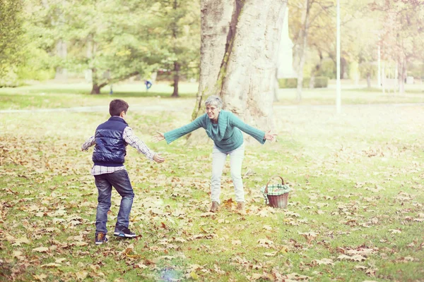 Menino correndo para a avó no parque — Fotografia de Stock