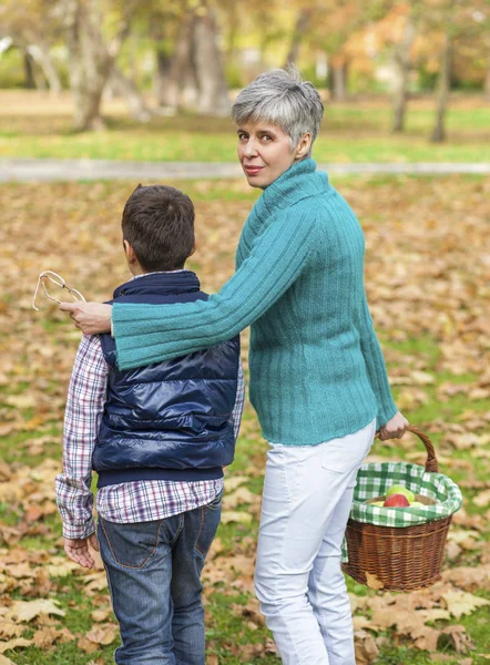 Bunica și nepotul merg la un picnic în parcul de toamnă — Fotografie, imagine de stoc