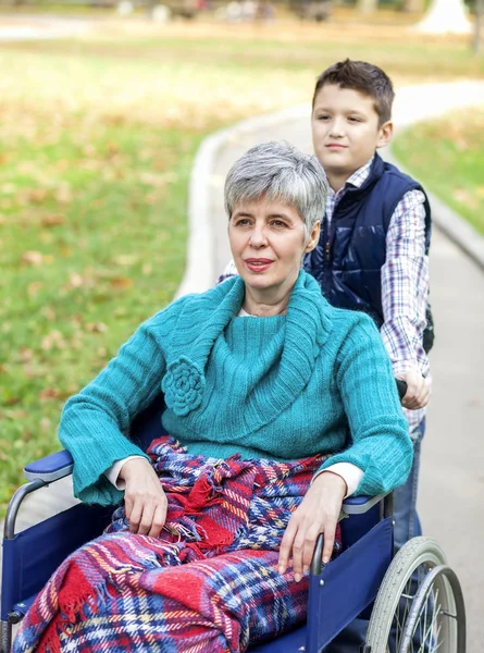 Nieto con la abuela en silla de ruedas en el parque — Foto de Stock