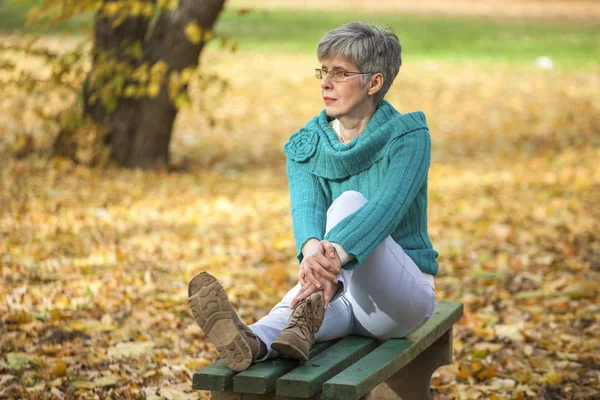 Keski-ikäinen nainen syksyllä puistossa — kuvapankkivalokuva