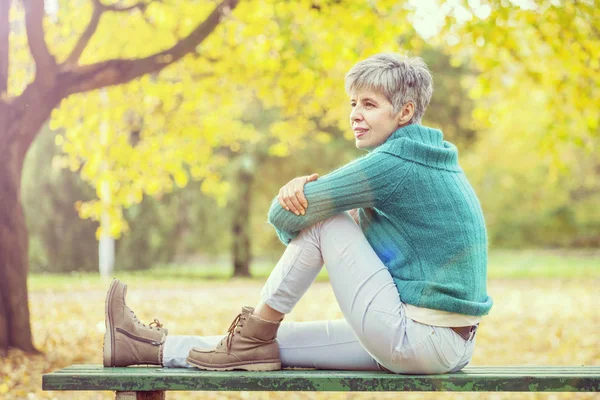 Středního věku žena v podzimním parku — Stock fotografie