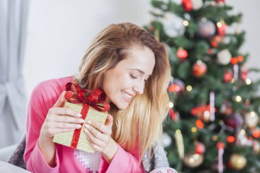 Kanepede bir Noel hediyesi tutan kadın