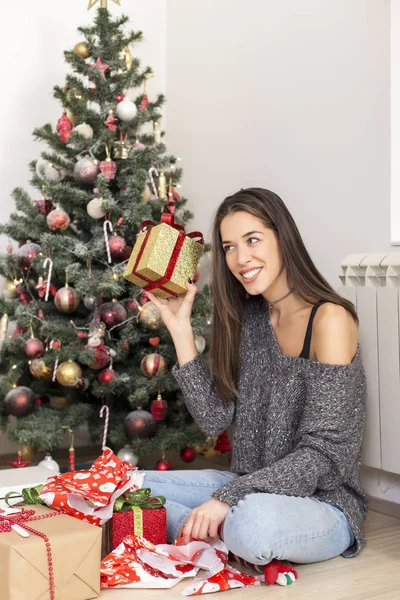 Donna accanto all'albero di Natale con un regalo — Foto Stock