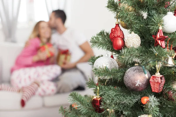 Árbol de Navidad con pareja enamorada en segundo plano —  Fotos de Stock