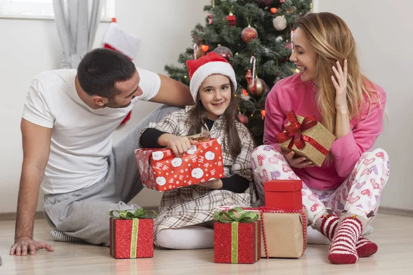 Familia frente a los regalos de apertura del árbol de Navidad —  Fotos de Stock