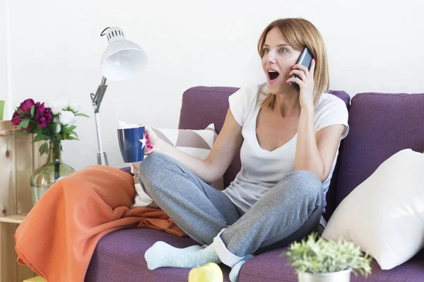 Donna in soggiorno con un telefono — Foto Stock