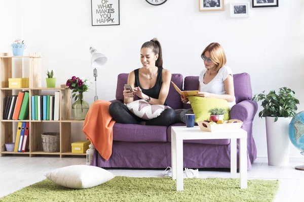Kvinnliga vänner samtala i vardagsrummet hemma — Stockfoto