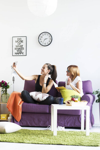 female friends taking a selfie in the living room