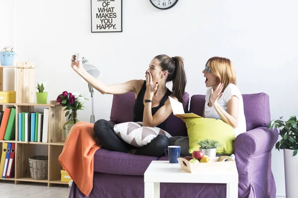 Kvinnliga vänner att ta en selfie i vardagsrummet — Stockfoto