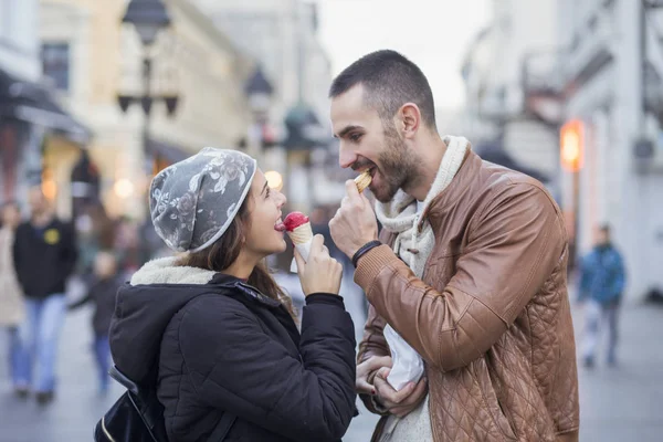 Jovem casal comendo na cidade — Fotografia de Stock