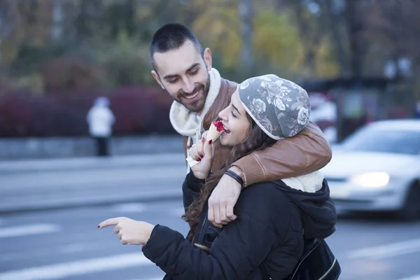 Jovem casal comendo na cidade — Fotografia de Stock