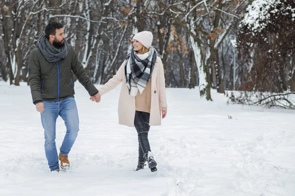 Casal feliz andando no parque de inverno — Fotografia de Stock