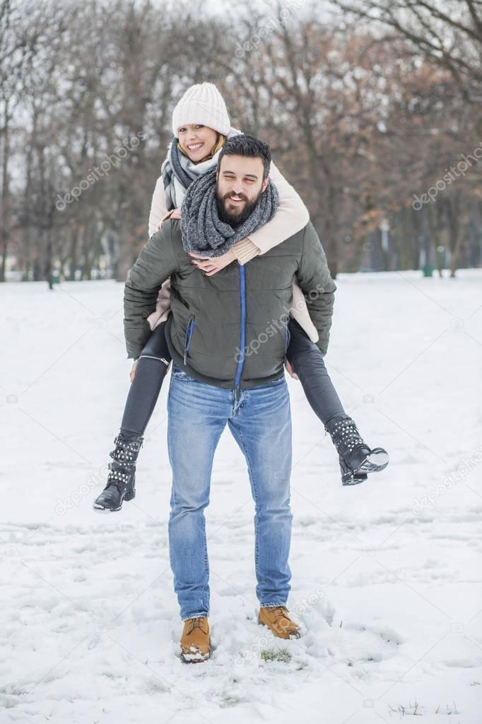 Happy couple walking in winter park 