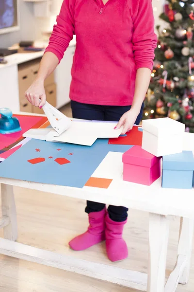 Frau macht Sammelalbum aus den Papieren, die auf dem Tisch liegen — Stockfoto