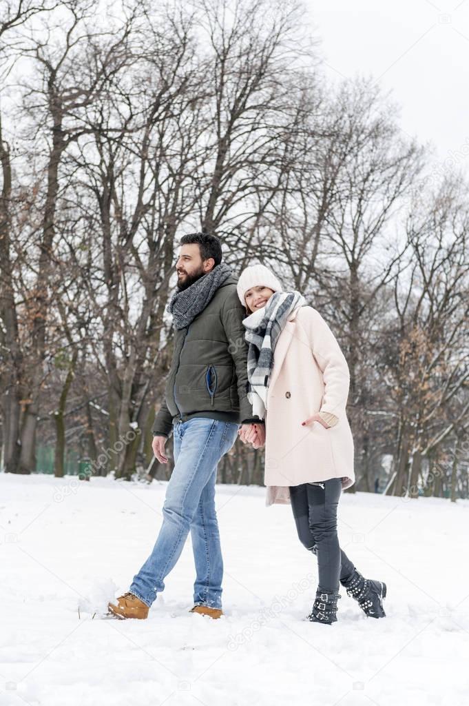 Loving couple enjoying the snow in the park