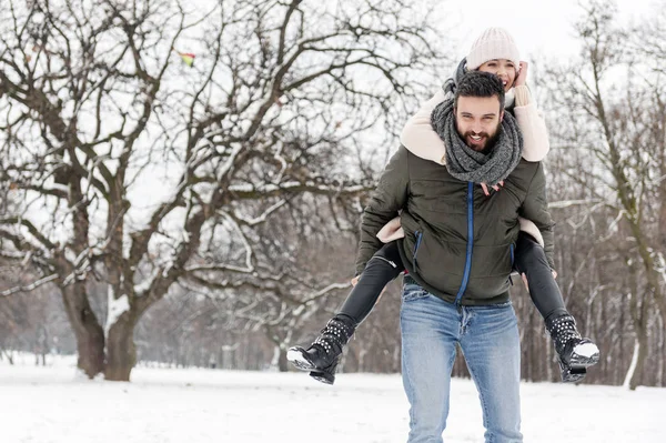 Liebespaar genießt den Schnee im Park — Stockfoto