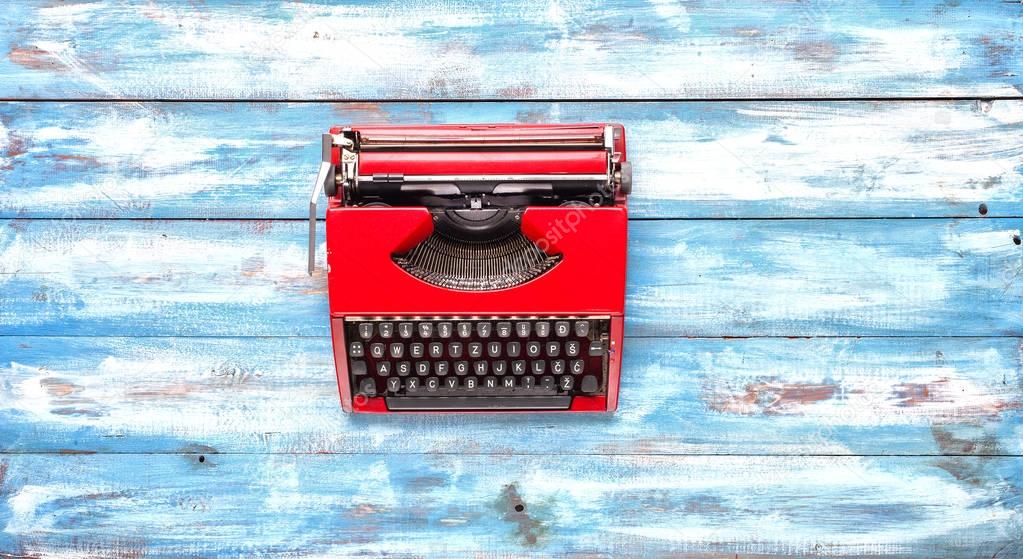 Old typewriter on vintage wooden background