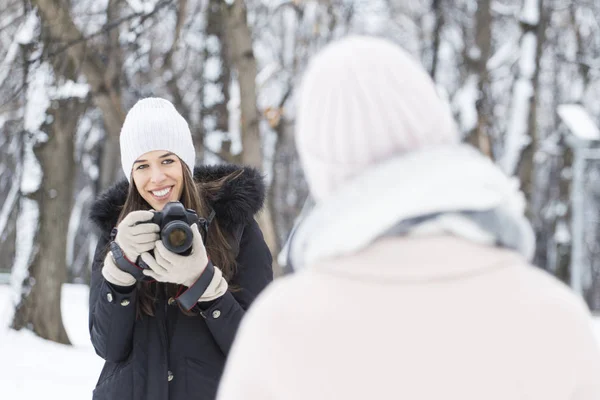 Жінка фотографує модель в зимовому парку — стокове фото