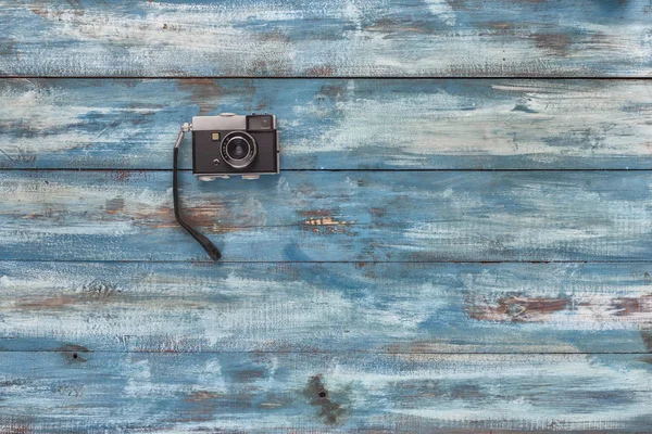 Foto câmera no fundo de madeira vintage — Fotografia de Stock