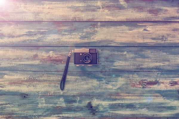 Фотокамера на старинном деревянном фоне — стоковое фото