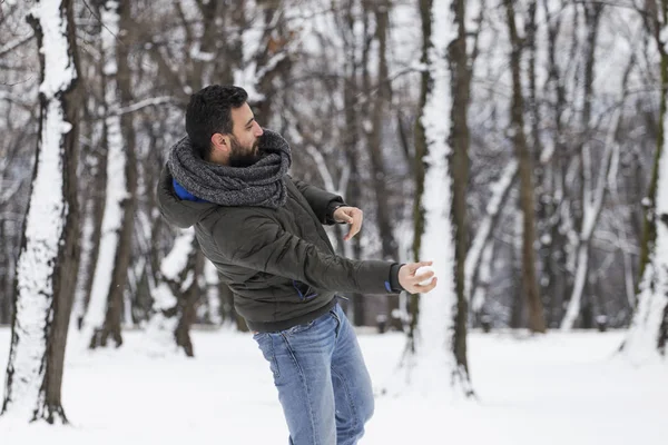 Человек, бросающий снежок — стоковое фото
