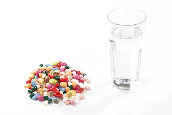 Pills capsules of medicament with water glass — Stock Photo, Image