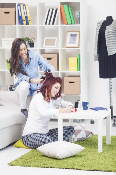 Chica rizando el pelo de un amigo con rodillos — Foto de Stock