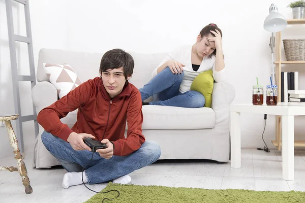 Meisje is verveeld en boos terwijl haar vriendje afspelen van video game — Stockfoto