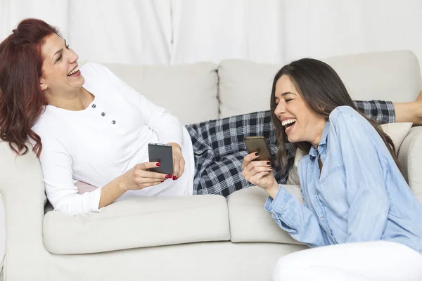 Kvinnliga vänner att ha kul ihop med smartphones — Stockfoto