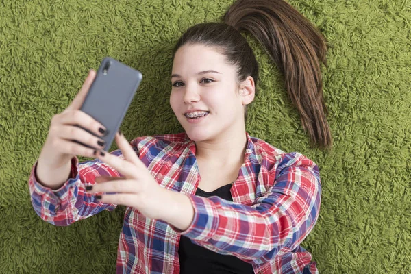 Tienermeisje liggend op de vloer selfie te nemen — Stockfoto
