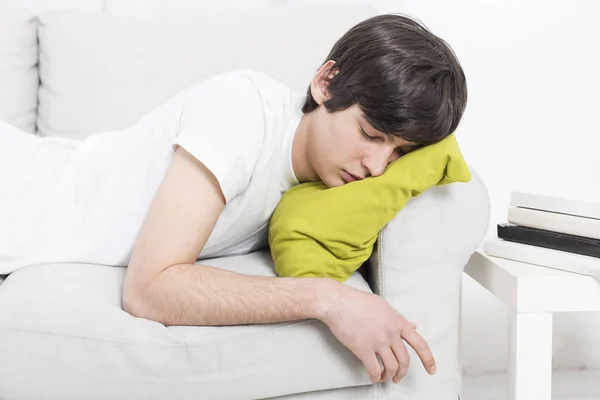 Cansado menino dormir sobre sofá enquanto estuda — Fotografia de Stock