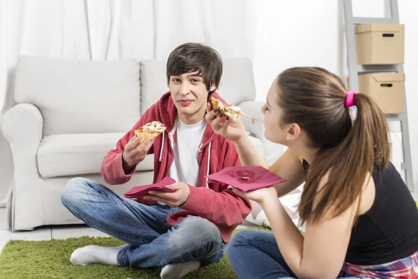 Friends hold pizza pieces and eat — Stock Photo, Image