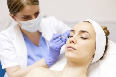 Woman receiving Botox injection clipart