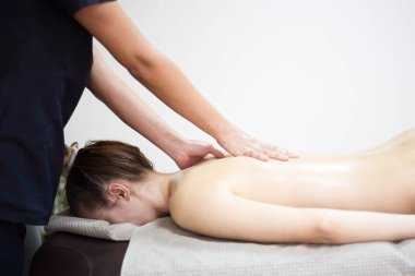 Spa salonunda masaj yaptıran bir kadın.