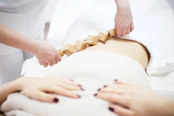 Anti cellulite massage for woman with rolling pins — Stock Photo, Image