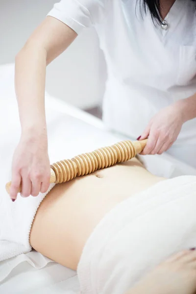 Anti cellulite massage for woman with rolling pins — Stock Photo, Image