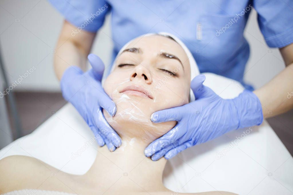 woman at spa salon applying facial mask