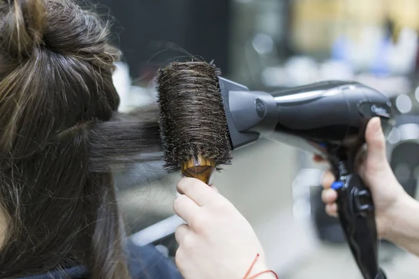 Torkning brunett hår med hårtork och rund hårborste, närbild — Stockfoto