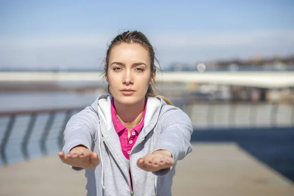 Morning exercise along the river. A young woman on recreation an — Stock Photo, Image