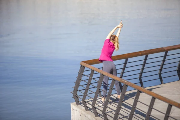 Sabah egzersiz Nehri boyunca. Genç bir kadın eğlence üzerinde bir — Stok fotoğraf