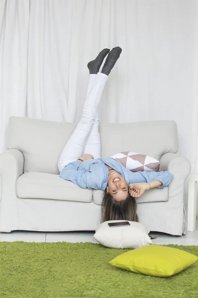 Женщина лежит на диване в гостиной — стоковое фото