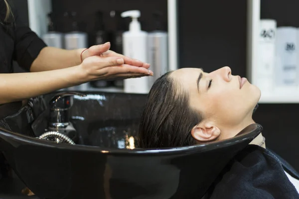 Mulher com cabeleireiro cabeça de lavagem no salão de cabeleireiro — Fotografia de Stock