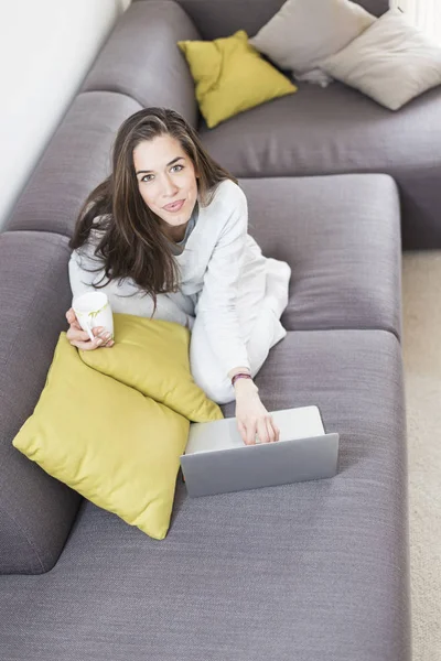 Jonge vrouw werkt op laptop thuis — Stockfoto