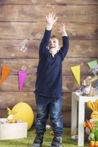 Счастливой Пасхи! Мальчик с мыльными пузырями играет — стоковое фото