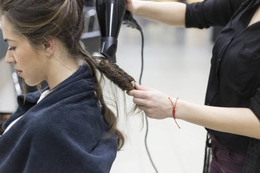 Saç kurutma makinesi ve yuvarlak fırça ile esmer saç kurutma