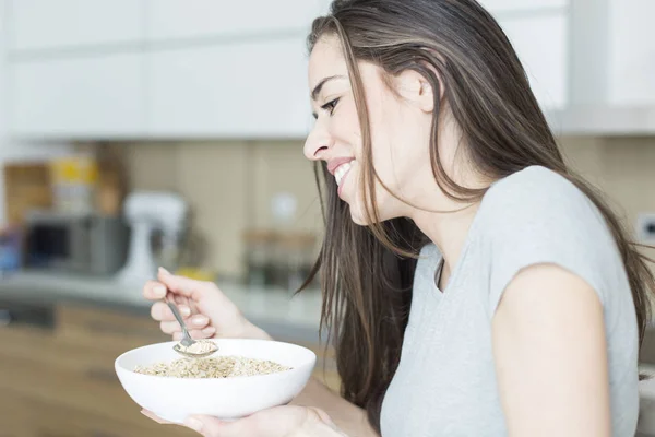 Morgon scen. Lycklig kvinna att ha friska frukostflingor — Stockfoto