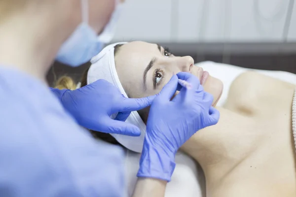 Beautician dibujar líneas de corrección en la cara de la mujer — Foto de Stock