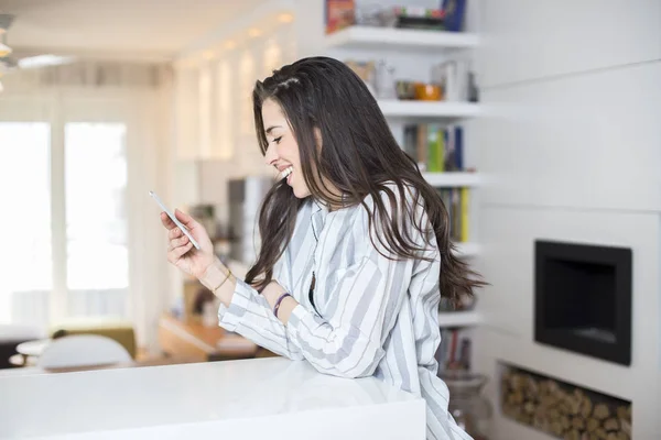 Mujer joven con teléfono en casa —  Fotos de Stock